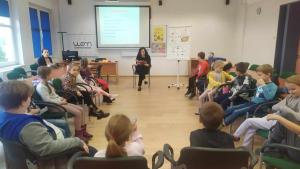 Prowadząca czyta fragment tekstu biblioterapeutycznego